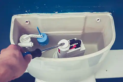plumber repairs toilet